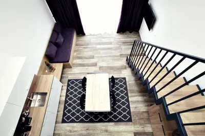 a room with a table and a couch and stairs at Apartments The Art House in Škofljica