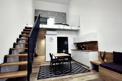 a kitchen and dining room with a table and a staircase at Apartments The Art House in Škofljica
