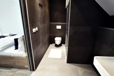 a small bathroom with a toilet and a sink at Apartments The Art House in Škofljica