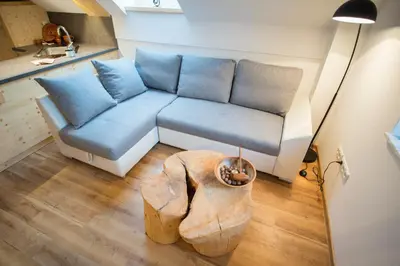 a living room with a blue couch and a table at Apartmaji Štrud´l Bohinj in Bohinj