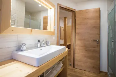 a bathroom with a white sink and a mirror at Apartmaji Štrud´l Bohinj in Bohinj