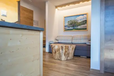 a living room with a couch and a log coffee table at Apartmaji Štrud´l Bohinj in Bohinj