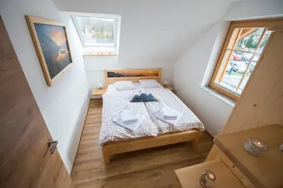 a small bedroom with a bed in a attic at Apartmaji Štrud´l Bohinj in Bohinj