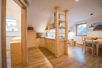 a kitchen with a ladder in the middle of a room at Apartmaji Štrud´l Bohinj in Bohinj