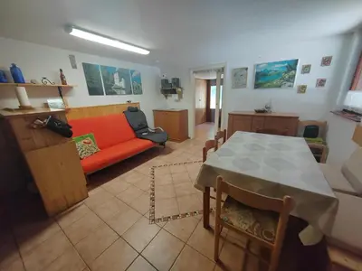 a living room with a red couch and a table at KOČA PLANIKA, SVIŠČAKI in Ilirska Bistrica