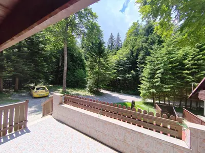 a balcony with benches and a yellow car on a road at KOČA PLANIKA, SVIŠČAKI in Ilirska Bistrica