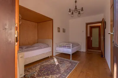 a bedroom with two beds and a chandelier at Vila Krpan Kranjska Gora in Gozd Martuljek