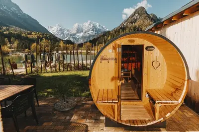 a wooden boat sitting on a patio with a table at JASNA NATUR Resort by the lake in Kranjska Gora