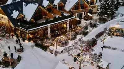 an aerial view of a christmas market in the snow at JASNA NATUR Resort by the lake in Kranjska Gora