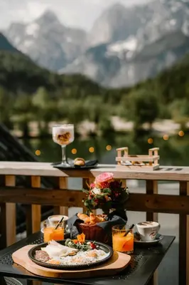 a table with a plate of food and a glass of wine at JASNA NATUR Resort by the lake in Kranjska Gora