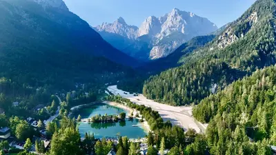 a river in a valley with mountains in the background at JASNA NATUR Resort by the lake in Kranjska Gora