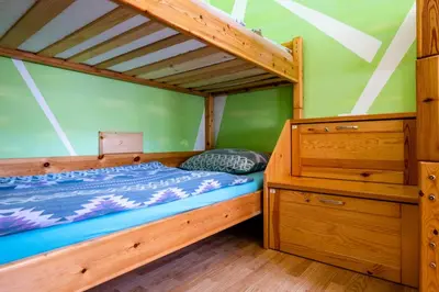 a bedroom with a bunk bed and a wooden dresser at Bled Hostel in Bled