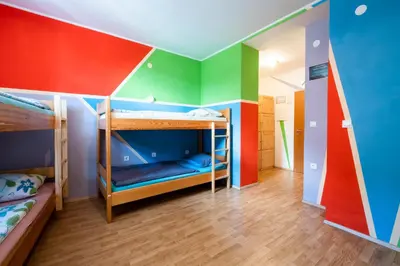 a room with two bunk beds with colorful walls at Bled Hostel in Bled