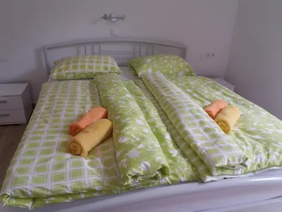 a bed with pillows and comforters on it at Apartma Momo in Bohinj