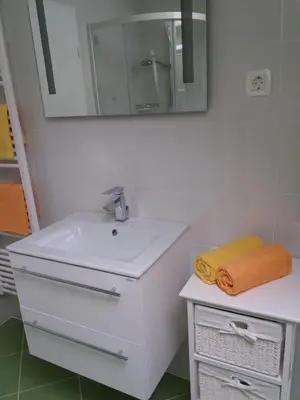 a white bathroom with a sink and a mirror at Apartma Momo in Bohinj