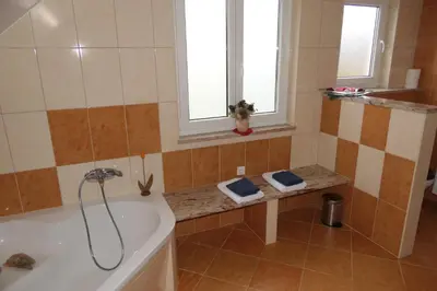 a bathroom with a bath tub and a window at Apartments and rooms Brunko in Bled