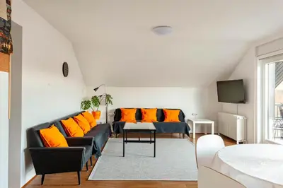 a living room with a couch and orange pillows at Island View Apartment in Bled