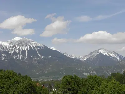 a snow covered mountain range with trees in front at Island View Apartment in Bled