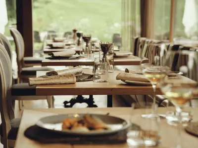 a table with plates of food and glasses of wine at Boutique hotel Vila Planinka in Zgornje Jezersko