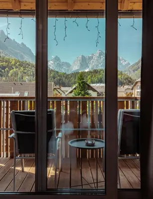 a view from the balcony of a house with a table and chairs at Boutique Skipass Superior Hotel in Kranjska Gora