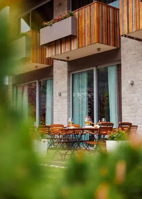 a table and chairs in front of a building at Boutique Skipass Superior Hotel in Kranjska Gora