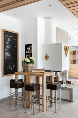 a table with black stools in a room at Boutique Skipass Superior Hotel in Kranjska Gora