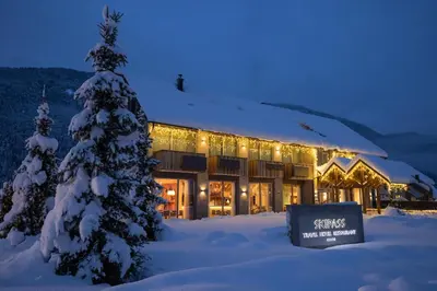 a building with a christmas tree in the snow at Boutique Skipass Superior Hotel in Kranjska Gora