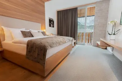 a bedroom with a large bed and a large window at Boutique Skipass Superior Hotel in Kranjska Gora