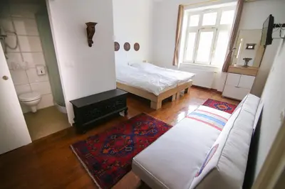 a living room with a bed and a couch at Hotel Vila Katrca in Ljubljana