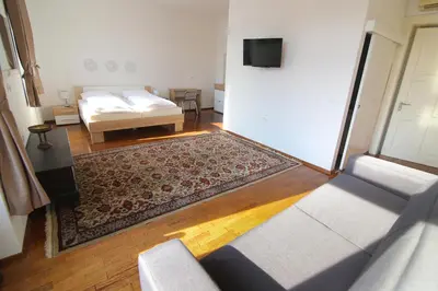 a living room with a bed and a couch at Hotel Vila Katrca in Ljubljana