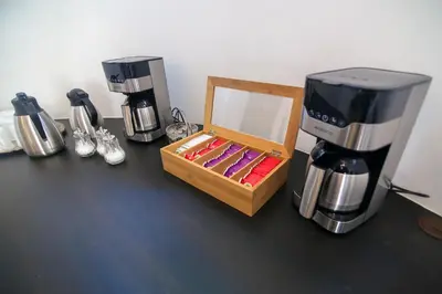 a counter with a coffee maker and a box on it at Hotel Vila Katrca in Ljubljana
