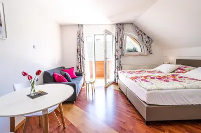 a bedroom with a bed and a table and a couch at Rooms Močilnik in Begunje na Gorenjskem