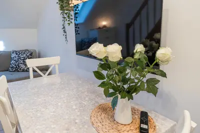 a vase with white roses sitting on a table at Rooms Močilnik in Begunje na Gorenjskem