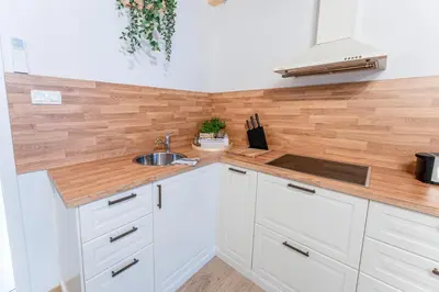 a kitchen with white cabinets and a sink at Rooms Močilnik in Begunje na Gorenjskem