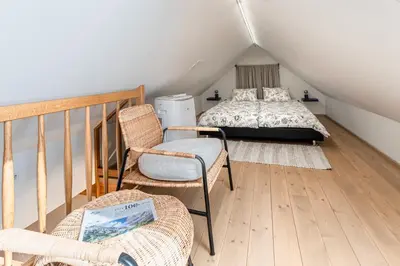 a attic room with a bed and a chair at Rooms Močilnik in Begunje na Gorenjskem