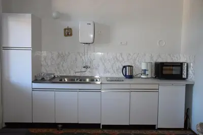 a white kitchen with a sink and a microwave at Vila Černe in Bled