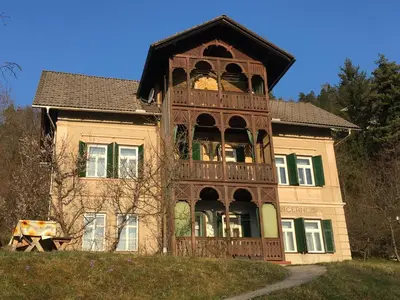 a large house with a balcony on the front of it at Vila Černe in Bled