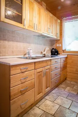 a kitchen with wooden cabinets and a sink at Chalet Letnik in Žiri