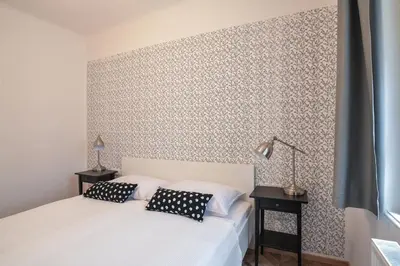 a bedroom with a white bed with two black pillows at Vila Selena in Ljubljana