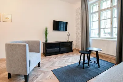 a living room with a chair and a tv and a table at Vila Selena in Ljubljana