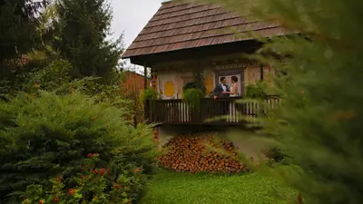 two people standing on a balcony of a house at Kendov Dvorec in Spodnja Idrija