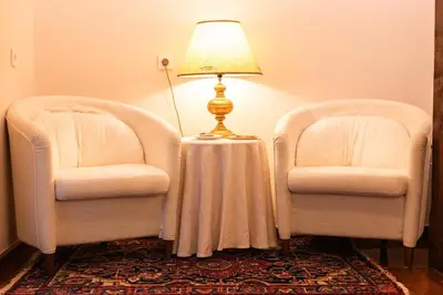 two chairs and a table with a lamp between them at Kendov Dvorec in Spodnja Idrija