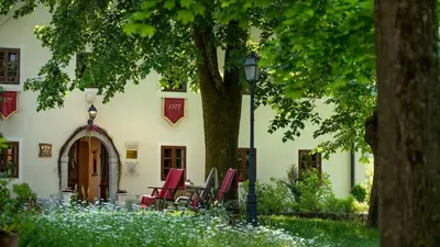 a group of chairs sitting outside of a building at Kendov Dvorec in Spodnja Idrija