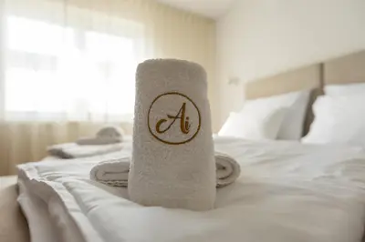 a towel sitting on top of a white bed at Bed & Breakfast Adelsberg Inn in Postojna