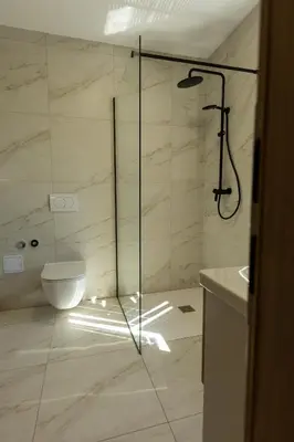 a bathroom with a shower and a toilet at Bed & Breakfast Adelsberg Inn in Postojna