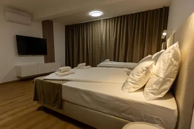 a hotel room with two beds and a flat screen tv at Bed & Breakfast Adelsberg Inn in Postojna