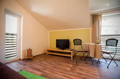 a living room with a tv and a table and chairs at Apartments Soča in Kobarid