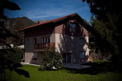 a large house with a balcony on the side of it at Apartments Soča in Kobarid