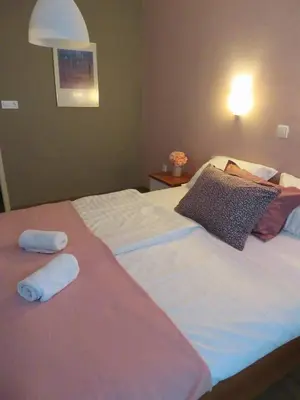 a bedroom with a large bed with two towels on it at Sobe ob Sotočju Budič Čatež ob Savi in Brežice