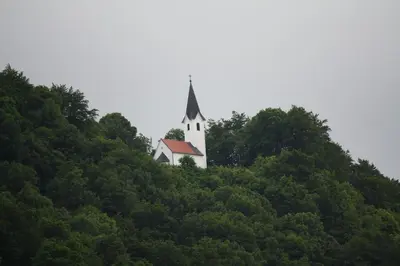 a church on top of a hill with trees at Sobe ob Sotočju Budič Čatež ob Savi in Brežice